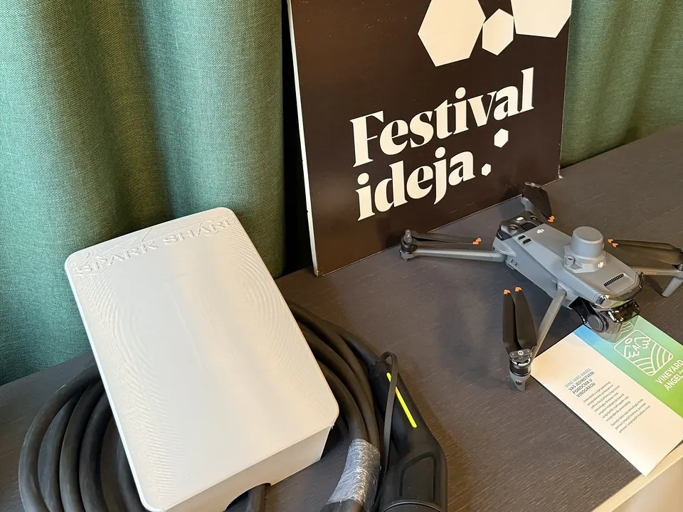White SparkShare BOXEV with a Type 2 cable next to the Festival of Ideas sign at Kent Klub