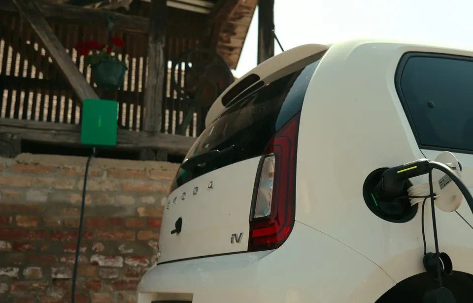 Green SparkShare BOXEV charging a white electric car